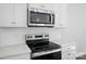 Close up of modern appliances including range top and microwave in a white kitchen at 908 Westminster Dr, Statesville, NC 28677
