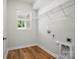 Laundry room features wood flooring, a window and wire shelving for added storage at 908 Westminster Dr, Statesville, NC 28677