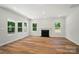 Bright living room showcasing wood floors, a fireplace, and views of the yard from the windows at 908 Westminster Dr, Statesville, NC 28677