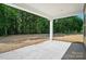 View of a covered concrete patio looking out onto a spacious yard with mature trees and a sense of peaceful tranquility at 908 Westminster Dr, Statesville, NC 28677