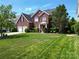 Charming two-story brick home with a manicured lawn, garden beds and a welcoming front porch at 9612 Indian Beech Nw Ave # 1266, Concord, NC 28027