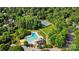 Aerial view of community pool and tennis courts surrounded by mature trees and greenery at 9927 Raddington Ln, Charlotte, NC 28269