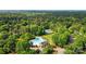 Aerial view of community pool and tennis courts surrounded by mature trees and greenery at 9927 Raddington Ln, Charlotte, NC 28269