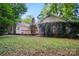 A backyard featuring a deck and a view of the home's exterior, surrounded by lush greenery at 9927 Raddington Ln, Charlotte, NC 28269
