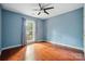 Spacious bedroom featuring wood floors, a ceiling fan, and abundant natural light at 9927 Raddington Ln, Charlotte, NC 28269