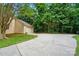 Long concrete driveway leading to a two-car garage with lush green grass and mature trees at 9927 Raddington Ln, Charlotte, NC 28269