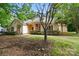Charming single-story home with a landscaped yard and an American flag on the porch at 9927 Raddington Ln, Charlotte, NC 28269