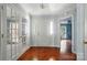 Bright foyer with hardwood floors, white trim, and double glass doors leading to another room at 9927 Raddington Ln, Charlotte, NC 28269