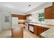 Functional kitchen with white appliances, wood cabinets, an island and a large window at 9927 Raddington Ln, Charlotte, NC 28269