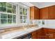 Kitchen featuring wood cabinets, a kitchen island, white appliances, and a window above the sink at 9927 Raddington Ln, Charlotte, NC 28269