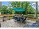 Outdoor entertaining area with dining table and seating, surrounded by mature trees at 1014 Vandalia Dr, Charlotte, NC 28212