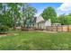 Backyard view features a deck and grassy yard, complemented by mature trees at 1014 Vandalia Dr, Charlotte, NC 28212