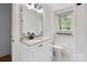Bright bathroom featuring white cabinets, quartz countertop, and modern black fixtures at 1014 Vandalia Dr, Charlotte, NC 28212