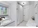 All-white bathroom with modern fixtures, natural light and a shower with a full-length shower curtain at 1014 Vandalia Dr, Charlotte, NC 28212