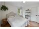 Bright bedroom featuring hardwood floors, white walls, a comfy bed, and a modern shelving unit at 1014 Vandalia Dr, Charlotte, NC 28212