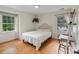 Inviting bedroom with light hardwood floors, white walls, and a comfy bed, enhanced by natural lighting at 1014 Vandalia Dr, Charlotte, NC 28212
