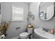 Stylish half bathroom featuring modern fixtures, decorative shelves, and a sleek oval mirror at 10418 Cullen Ct, Charlotte, NC 28278
