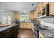 Well-lit kitchen features granite countertops, stainless steel appliances, tile backsplash, and wood cabinets at 10418 Cullen Ct, Charlotte, NC 28278