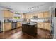 Bright kitchen features an island, stainless steel appliances, wood cabinets, and granite countertops at 10418 Cullen Ct, Charlotte, NC 28278