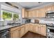 Close up on kitchen area showcasing a window, stainless steel appliances, granite countertops, and wood cabinets at 10418 Cullen Ct, Charlotte, NC 28278