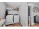 Functional laundry room with modern washer and dryer, ample shelving for storage, and a door to the bathroom at 10418 Cullen Ct, Charlotte, NC 28278