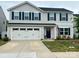 Charming two-story home with light gray siding, a two-car garage, and an inviting navy blue front door at 115 Crownpiece St, Troutman, NC 28166