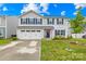 Traditional two-story home featuring light gray siding, a two-car garage, and manicured lawn at 115 Crownpiece St, Troutman, NC 28166