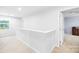 Well-lit hallway area with neutral carpet and view from the window at 115 Crownpiece St, Troutman, NC 28166