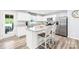 Modern kitchen featuring a large island, white cabinets, granite countertops, and stainless appliances at 115 Crownpiece St, Troutman, NC 28166