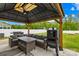 Relaxing covered patio area with outdoor furniture and BBQ grill at 115 Crownpiece St, Troutman, NC 28166