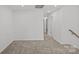 Hallway with neutral carpeting and white walls leads to various rooms, illuminated by recessed lighting at 14028 Parkside Crossing Dr # 331, Charlotte, NC 28273