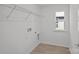 Bright laundry room with white walls, window and wire rack shelving at 14028 Parkside Crossing Dr # 331, Charlotte, NC 28273