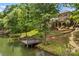 Beautiful backyard with a waterfront view, a wooden dock, and a cozy fire pit area at 141 Ridge Top Rd, Mooresville, NC 28117