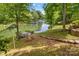 Waterfront property featuring a dock, a fire pit, and mature trees for ample privacy by the lake at 141 Ridge Top Rd, Mooresville, NC 28117