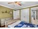 Comfortable bedroom with light green walls, crown molding, ceiling fan, and hardwood floors at 141 Ridge Top Rd, Mooresville, NC 28117