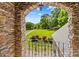 Stone archway provides a unique view of the front yard and driveway lined with trees and landscaping at 141 Ridge Top Rd, Mooresville, NC 28117