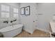 Elegant bathroom featuring a freestanding tub, herringbone tile floor, and natural light at 1502 Matthew Mcclure Cir, Davidson, NC 28036