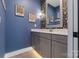 Chic bathroom with navy blue walls, decorative wallpaper, and a white marble countertop vanity at 1502 Matthew Mcclure Cir, Davidson, NC 28036