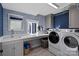 Modern laundry room with blue wallpaper, white washer and dryer, and a sink at 1502 Matthew Mcclure Cir, Davidson, NC 28036