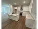 Modern kitchen with white cabinets, stainless steel appliances, an island, and wood-look flooring at 1563 Riverview Cir, Fort Lawn, SC 29714