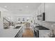 Open-concept kitchen flows into living area with stainless steel appliances, white cabinetry, and center island at 15926 Parkside Crossing Dr # 322, Charlotte, NC 28273