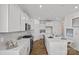 Bright kitchen features white cabinetry, quartz countertops, stainless steel appliances, and center island with sink at 15926 Parkside Crossing Dr # 322, Charlotte, NC 28273
