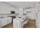 Modern kitchen with white cabinets, quartz countertops, stainless steel appliances, and an island at 15926 Parkside Crossing Dr # 322, Charlotte, NC 28273
