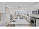 Bright, open-concept kitchen with island, white cabinetry, stainless appliances; living room in background at 15926 Parkside Crossing Dr # 322, Charlotte, NC 28273