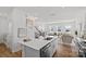 Open-concept kitchen and living room with white cabinetry, stainless steel appliances, island with seating at 15926 Parkside Crossing Dr # 322, Charlotte, NC 28273