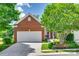 Charming single-Gathering brick home with a two-car garage and a beautifully landscaped front yard with mature trees at 1678 Onyx Rdg, Fort Mill, SC 29708