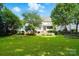Large grassy backyard with mature trees, a trampoline, and a playset at 201 Mills Ln, Fort Mill, SC 29708
