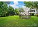 Large grassy backyard with mature trees, a trampoline, and a swing at 201 Mills Ln, Fort Mill, SC 29708