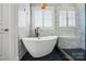 Modern bathroom features a freestanding tub, marble walls, hexagon tile floor, and stylish fixtures at 201 Mills Ln, Fort Mill, SC 29708