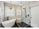 Contemporary bathroom with marble walls, black fixtures, freestanding tub, and glass-enclosed shower at 201 Mills Ln, Fort Mill, SC 29708